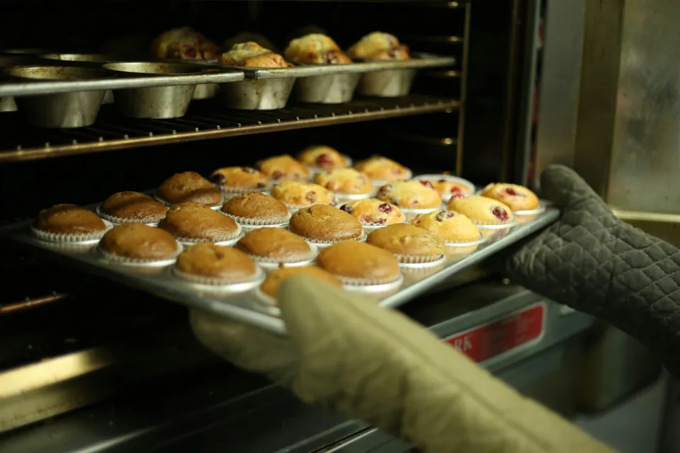 Freshly baked cupcakes coming out of an oven